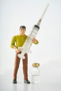 Toy figure holding syringe representing GLP-1 weight loss injection treatment under doctor supervision India