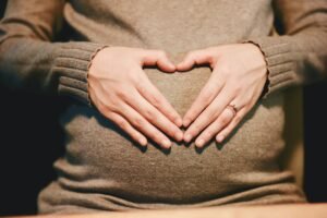 Hands forming a heart over the abdomen to represent metabolic health and personalized wellness